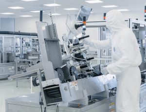 Sterile High Precision Manufacturing Laboratory where Scientists in Protective Coverall's Turn on Machninery, Use Computers and Microscopes, doing Pharmaceutics, Biotechnology and Semiconductor Research.