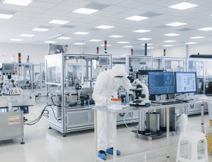Shot of Sterile Pharmaceutical Manufacturing Laboratory where Scientists in Protective Coverall's Do Research, Quality Control and Work on the Discovery of new Medicine.